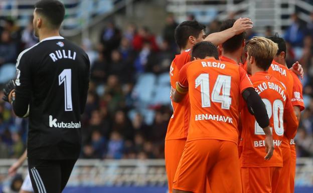 Los malaguistas celebran el segundo gol en Anoeta, con Rulli a la izquierda lamentándolo. :/AGENCIA LOF