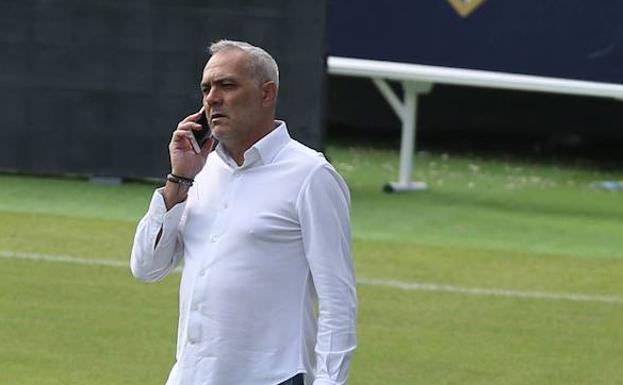 Husillos habla por teléfono en La Rosaleda. /Salvador Salas