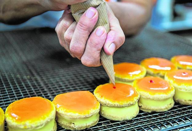 El punto de guinda.El punto de crema de guinda se aplica entre la primera y la segunda capa del glaseado de azúcar de color naranja./Daniel Maldonado