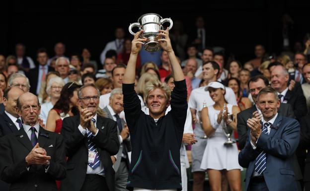 Davidovich, pleno de felicidad, alza el trofeo ayer en el All England Club.