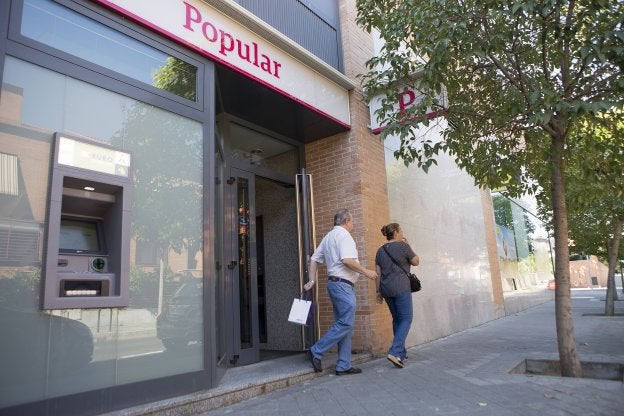 Dos clientes salen de una oficina del Banco Popular en Madrid . :: virginia carrasco