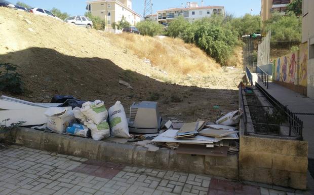 Enseres, escombros y restos de muebles, a pie de acera.