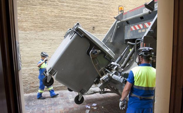 Operarios recogiendo la basura de un contenedor.