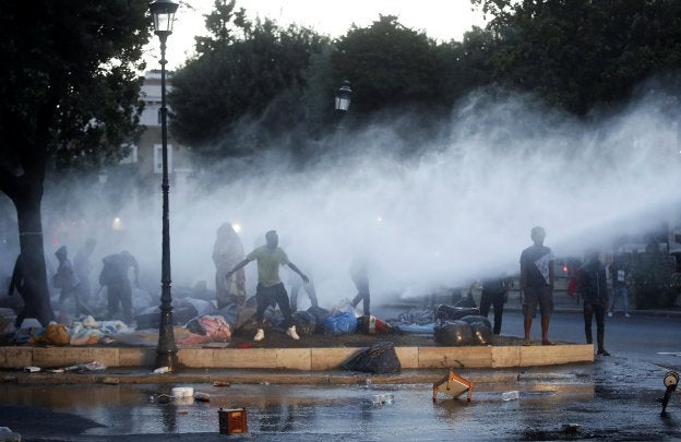 Los antidisturbios italianos desalojan con agua a presión un campamento de refugiados en una plaza de Roma. :: reuters