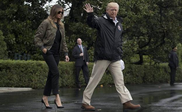 Donald Trump (d) y Melania Trump (i) se dirigen al helicóptero presidencial.