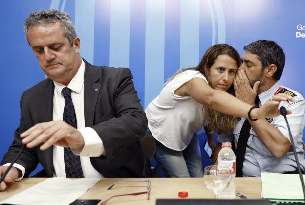 El mayor de los Mossos conversa con la responsable de redes sociales de la policía catalana, ayer, junto al consejero de Interior. :: A. Dalmau / efe