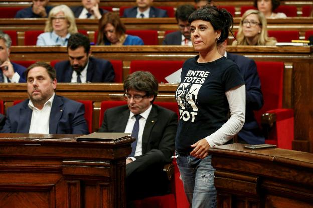 La diputada de la CUP, Anna Gabriel, pasa delante del presidente Puigdemont y el vicepresidente Junqueras ayer durante el pleno del Parlamento catalán. :: a. egea/reuters
/