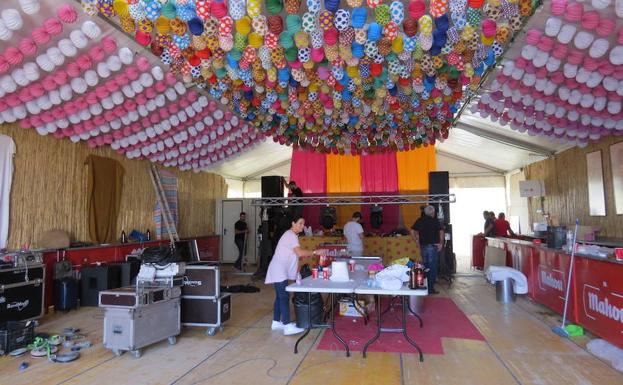 Varias personas montando ayer una de las 16 casetas para adultos que funcionarán en la feria./Josele-Lanza -