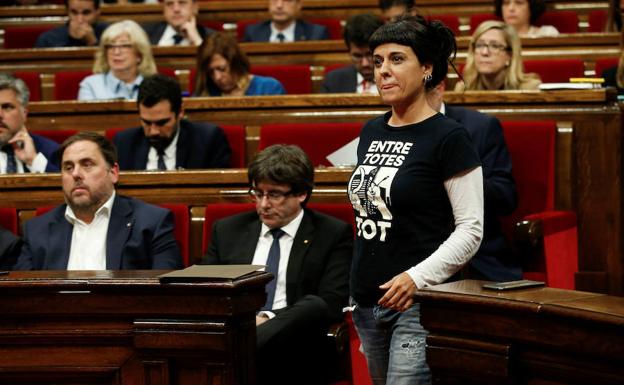 La diputada de la CUP, Anna Gabriel, pasa por delante del escaño de Puigdemont./Reuters