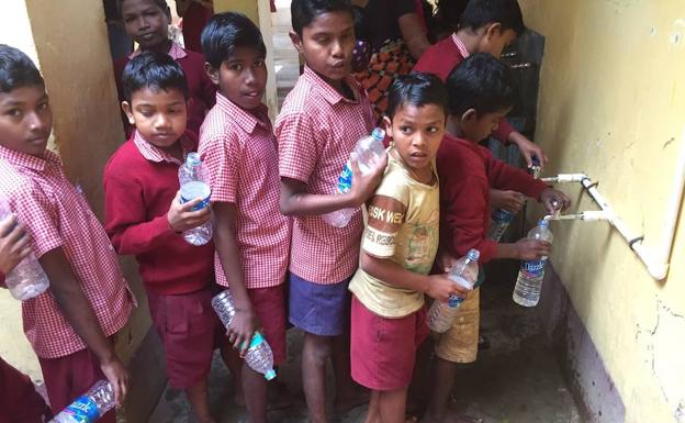 Alumnos de la escuela de Puri rellenan sus botellas de agua./Sur