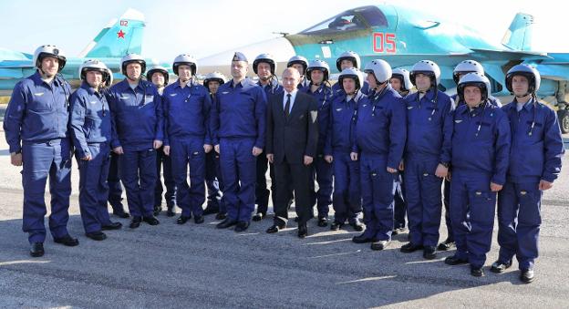 Putin posa con pilotos de los cazas rusos desplegados en la base aérea de Hmeimim, en Siria. :: M. Klimentyev / AFp/