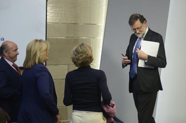 Rajoy se acerca a sus ministros de Economía, Empleo y Agricultura tras analizar ayer en la Moncloa los resultados del 21-D. :: Maya Balanya/