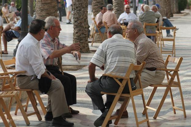 Un gupo de personas, de tertulia en una calle de Alicante. :: CARLOS RODRÍGUEZ/
