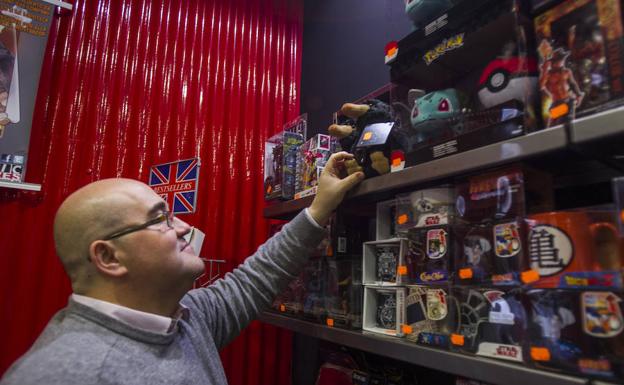 Miguel Ángel Díaz coloca unos artículos de ‘merchandising’ en la tienda del Soho de la empresa malagueña /Fran Acevedo