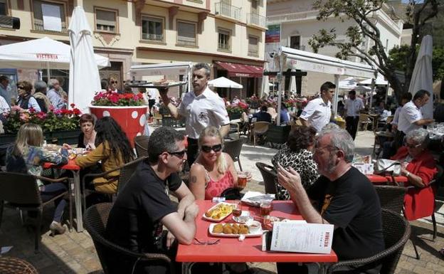 Imagen de archivo de varios camareros trabajando en la terraza de un bar. /SUR