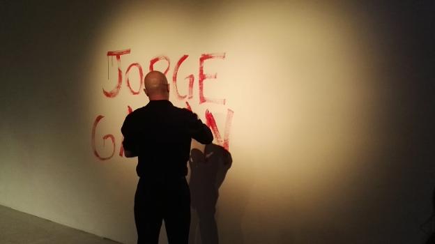 Jorge Galán, mientras pinta su nombre con su sangre en una pared de la sala. :: s. m./