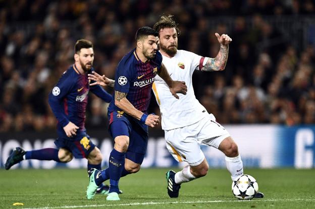 Luis Suárez se interna pese a la oposición del italiano De Rossi y ante la mirada de Leo Messi, ayer en Camp Nou. :: Filippo MONTEFORTE / Afp/