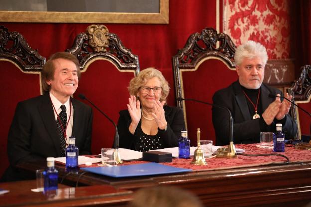 Raphael, la alcaldesa de Madrid, Manuela Carmena, y Pedro Almódovar, en el salón de plenos del antiguo ayuntamiento. :: r. c./