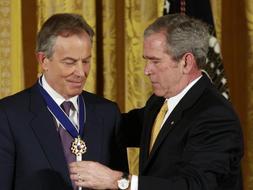 Momento en el que George W. Bush impone la condecoración al ex primer ministro británico Tony Blair durante la ceremonia que se ha celebrado en la Casa Blanca. /Reuters/