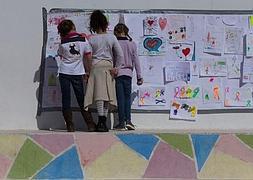 Tres niñas observan los murales que los alumnos han realizado para despedir a su profesora.:: Ñito Salas / Vídeo: Inma Pérez y Rossel Aparicio/