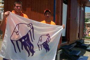 TORREMOLINOS. Dos voluntarios de Protección Civil, ayer con una bandera de medusas en El Saltillo. / E. C./