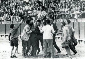 La cara, en 1960, la primera vez que salía a hombros por la Puerta del Príncipe de la Maestranza de Sevilla. Abajo, la cruz, en 1987, abandona Las Ventas protegido por la Policía. :: R. C./