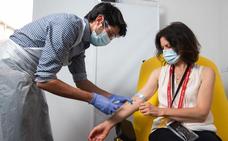 Un sanitario administra la vacuna a una voluntaria/EP