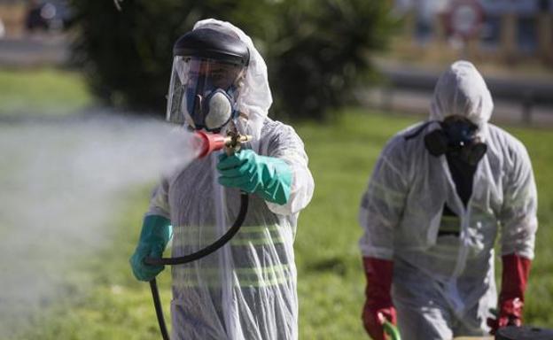 Imagen de archivo de dos trabajadores fumigando contra los mosquitos que causan el virus del Nilo./EP